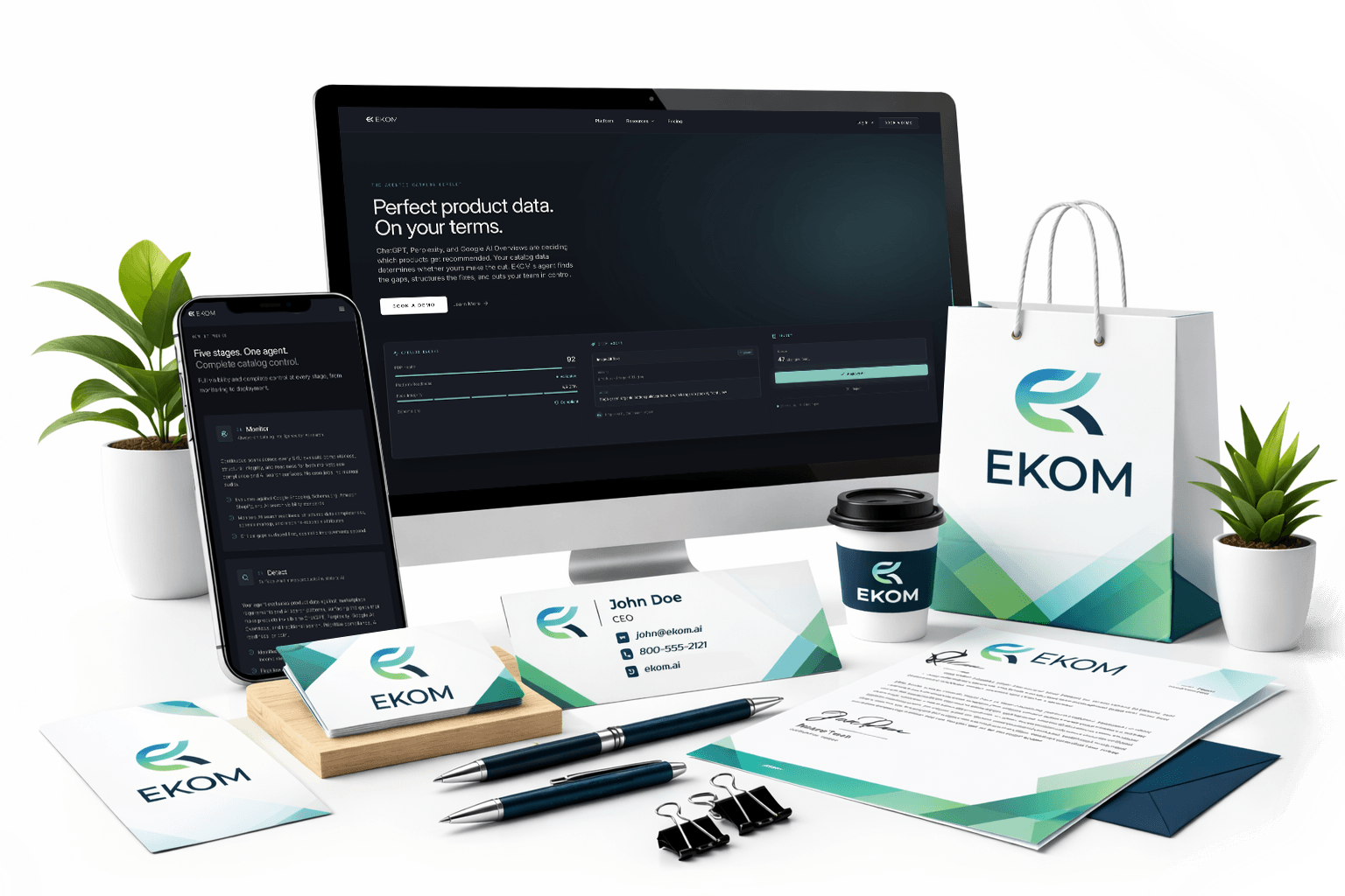 Branded business collateral featuring EKOM logo on a computer screen, smartphone, stationery, coffee cup, and shopping bag, illustrating cohesive brand identity and marketing assets.